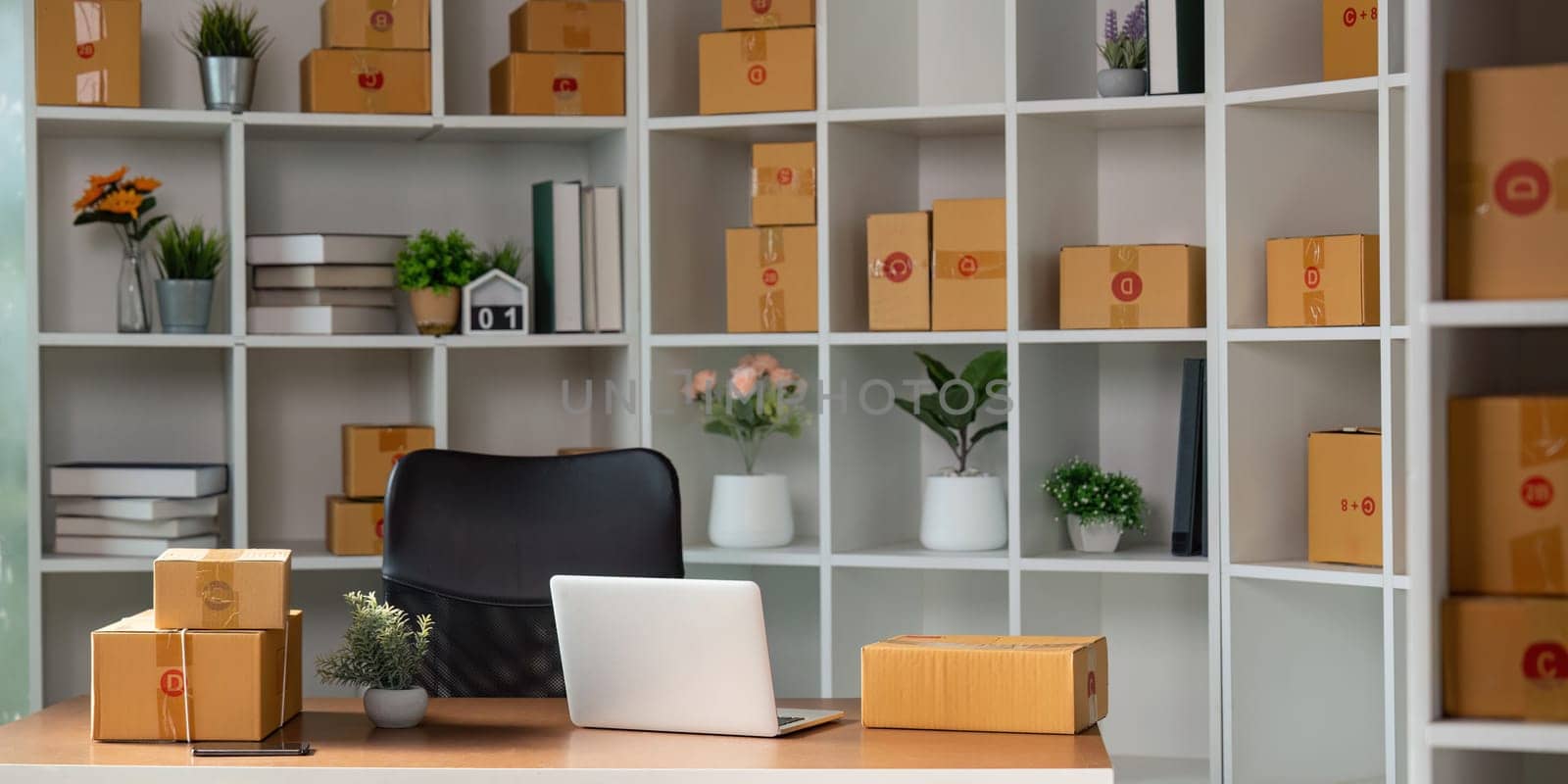 A well-organized home office featuring packages prepared for online sales and a laptop setup, representing a modern workspace for entrepreneurship.