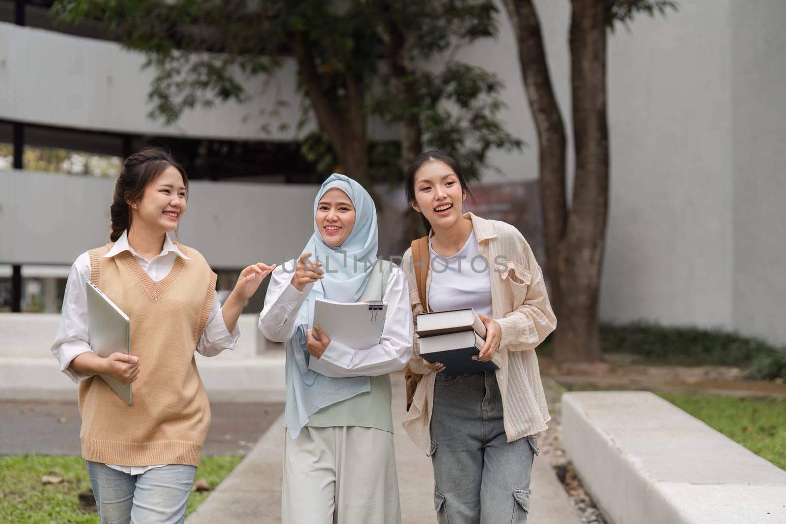 A group of diverse university students walking together and engaging in cheerful conversation while enjoying their time on campus.