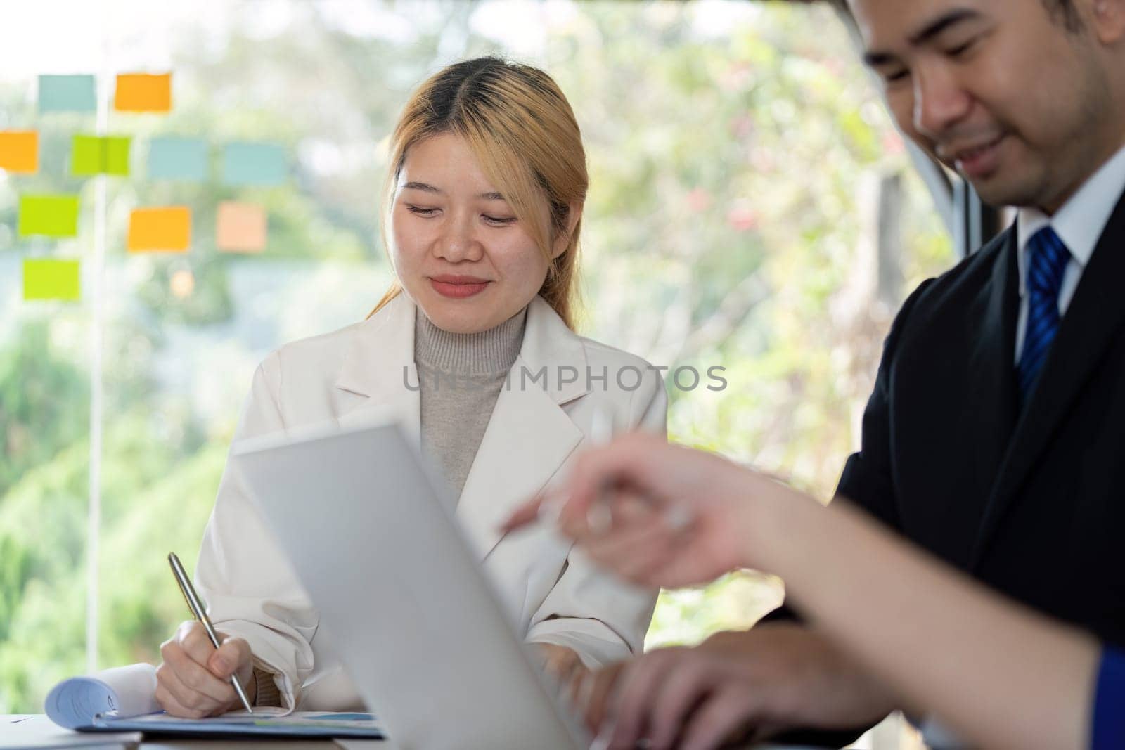 A multicultural business team engaging in productive discussion and analysis, showcasing teamwork and professionalism in a contemporary office environment.