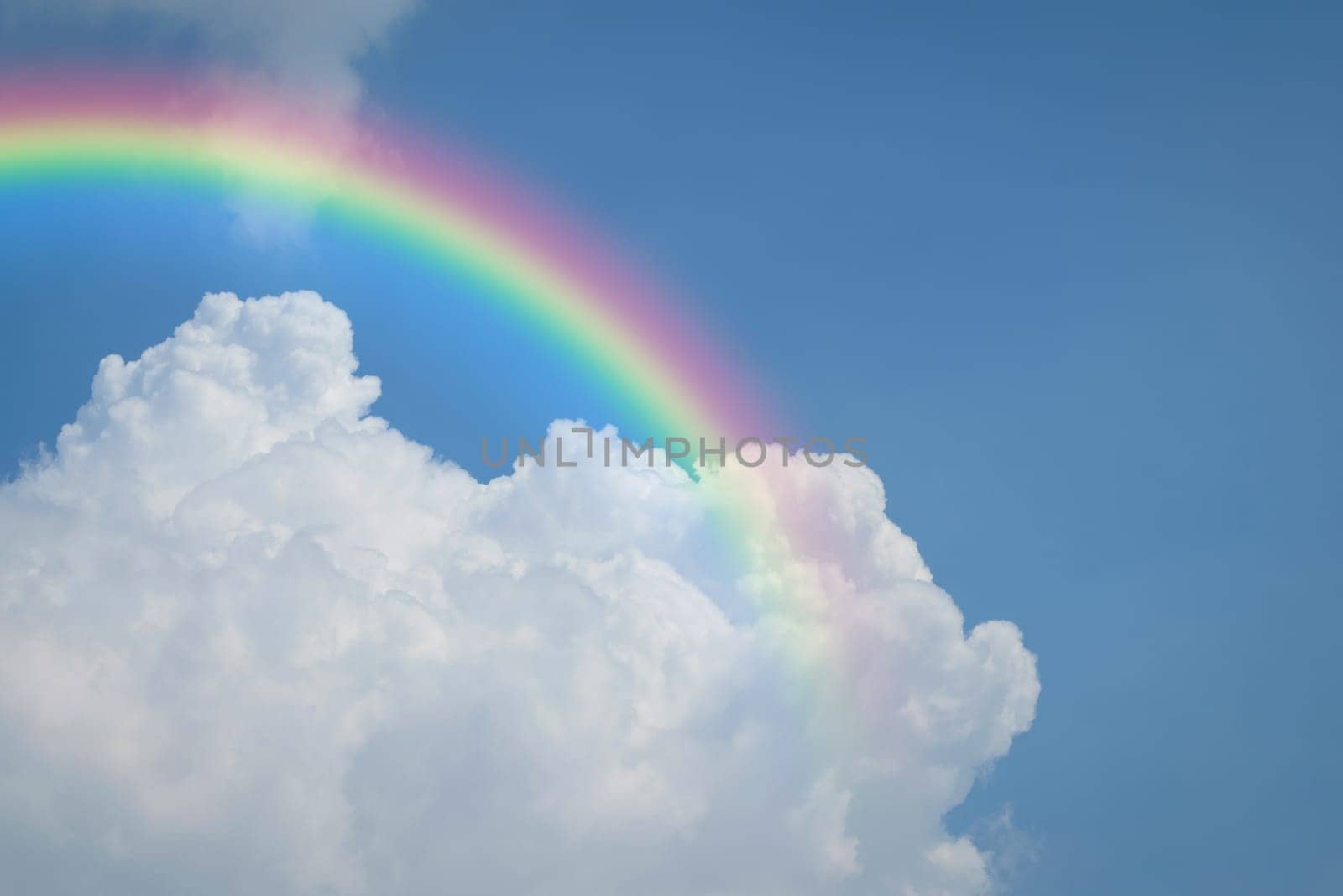 Nature cloudscape with blue sky and white cloud with rainbow