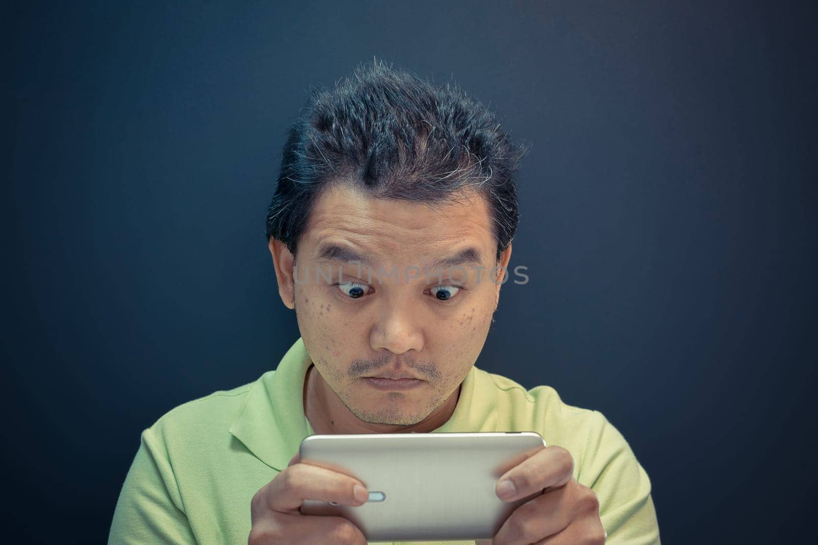 Asia man dazed and shock using smartphone on black background , process in vintage style
