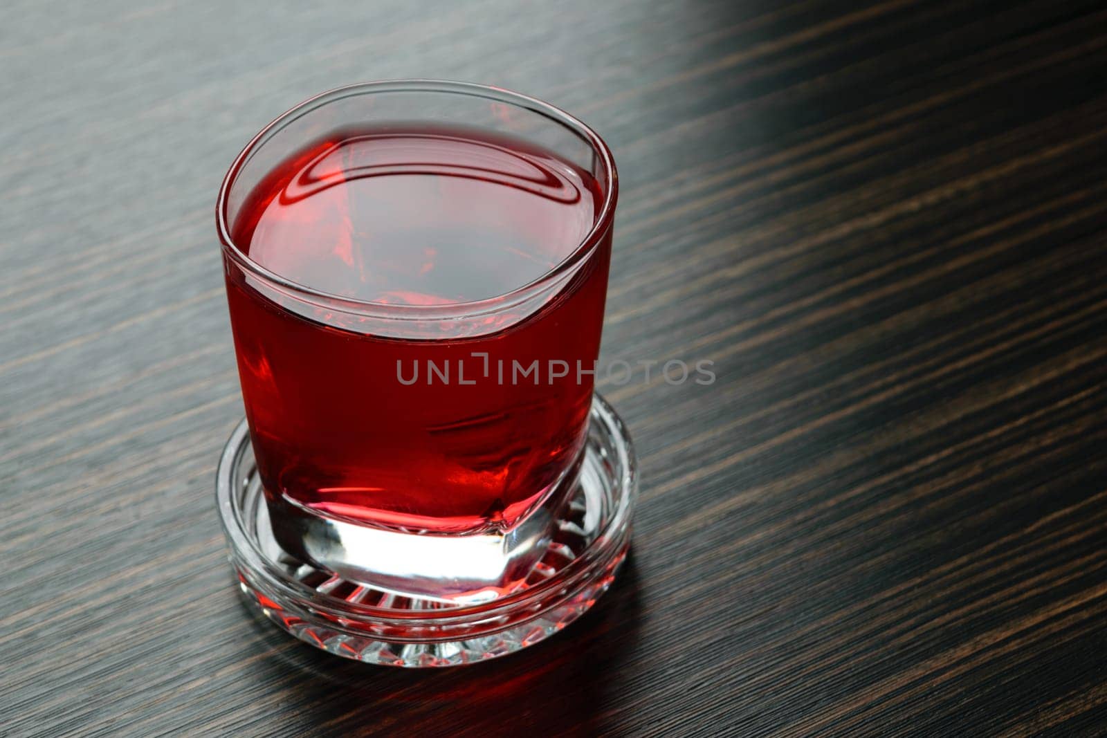Sweet red water drink in glass on wood table