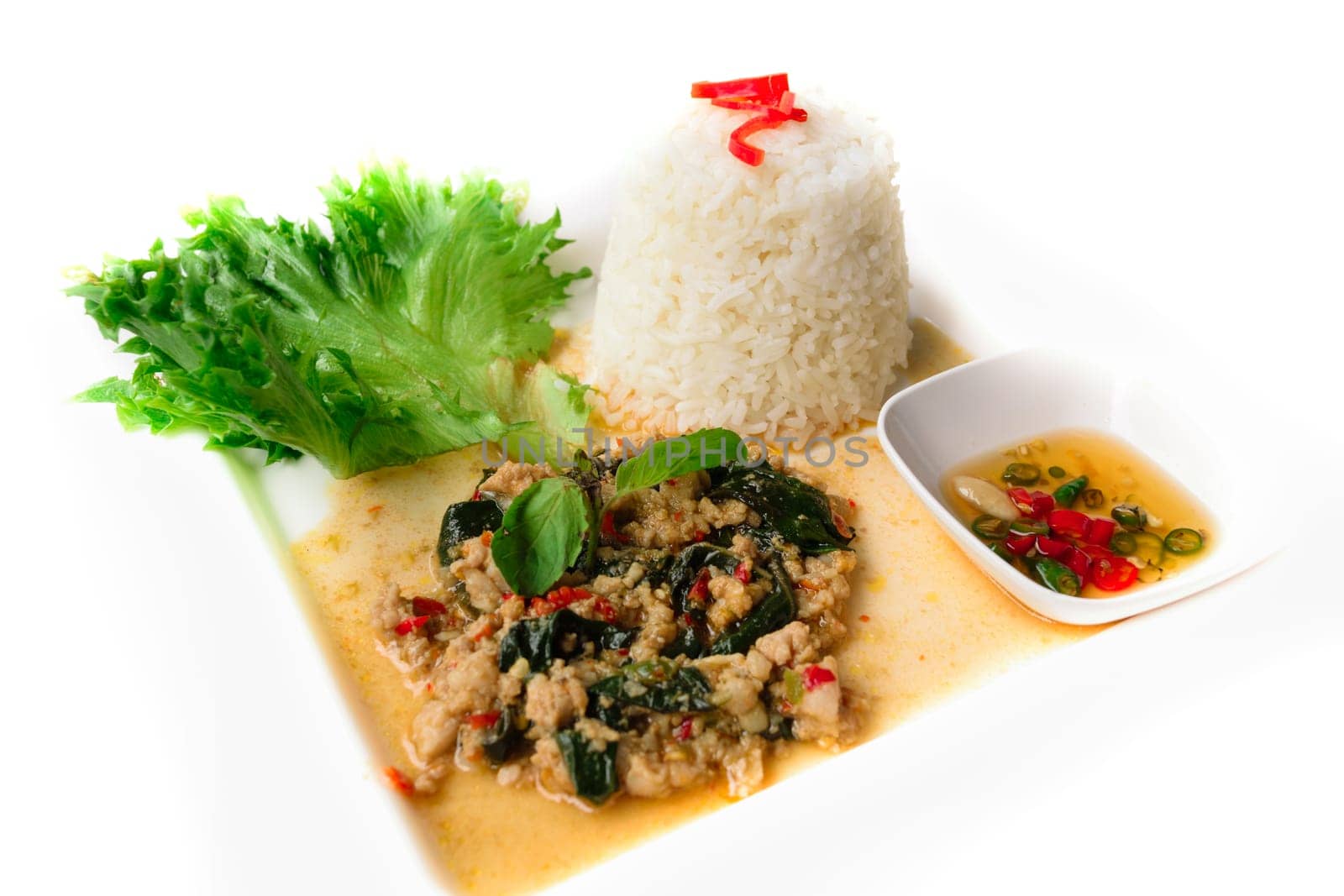 Rice topped with stir-fried pork and basil isolated on white background