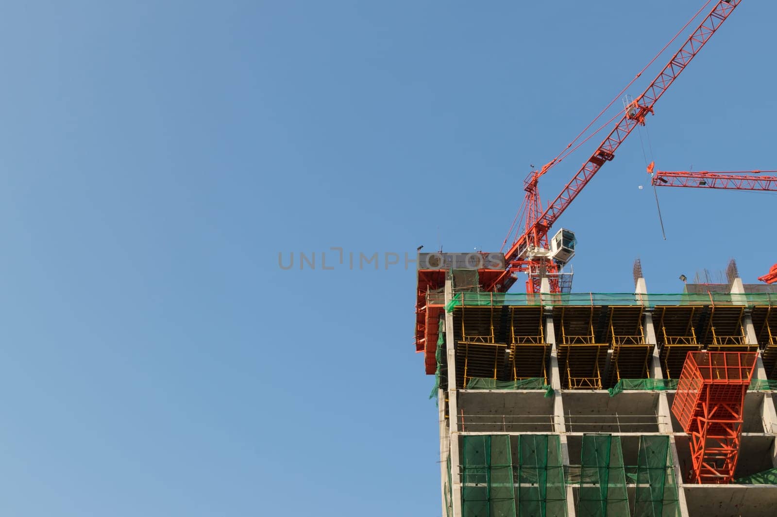 Crane with office building construction and blue sky