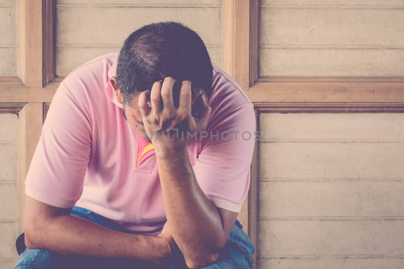 Anxious asian man feeling sadness and stress sitting on the chair , process in vintage style