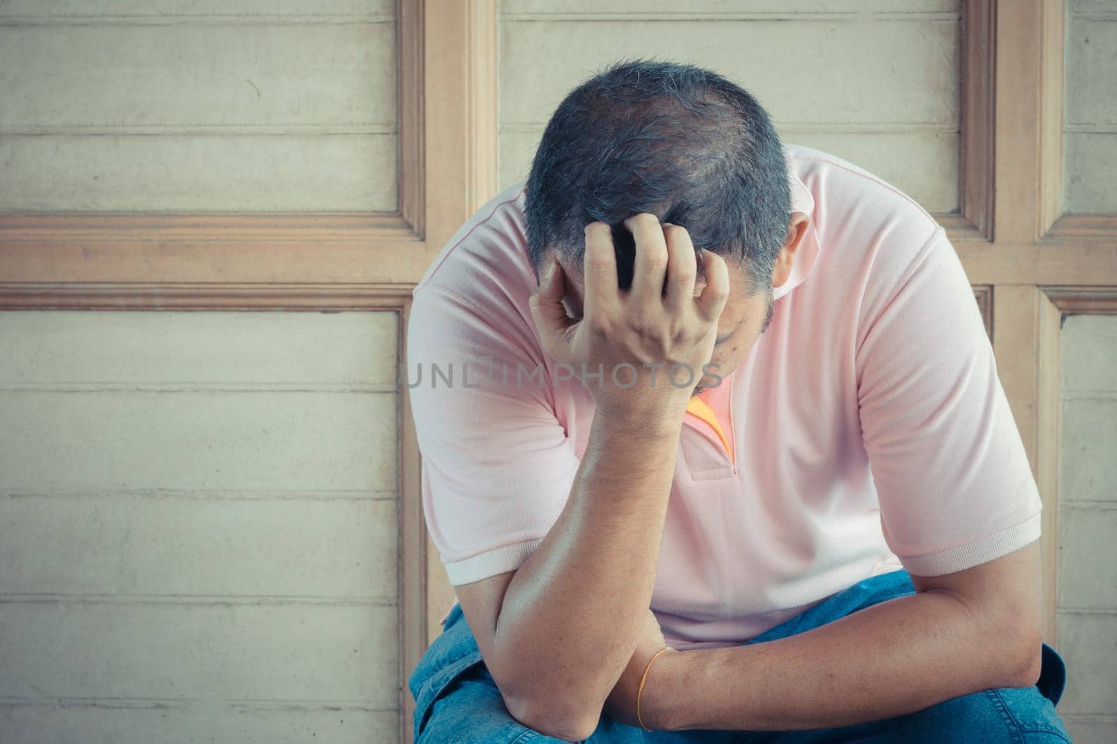Anxious asian man feeling sadness and stress sitting on the chair , process in vintage style