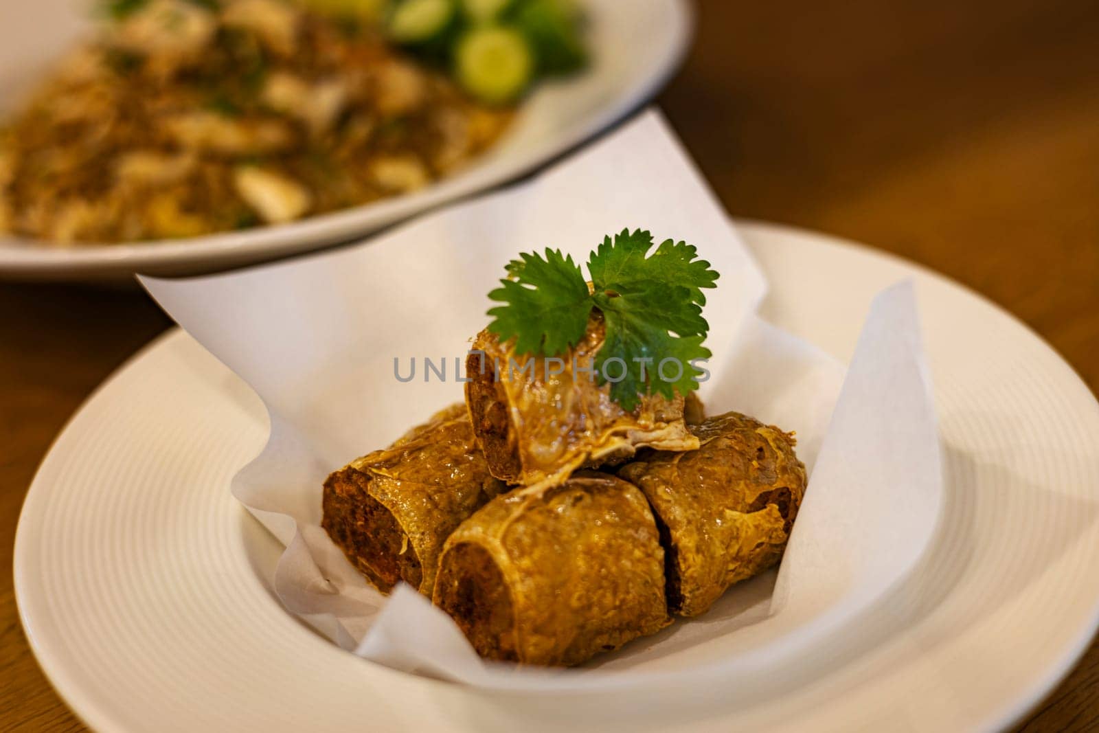 Crispy Tofu Skin Rolls With Crab. Deep fried crap meat roll on white dish.