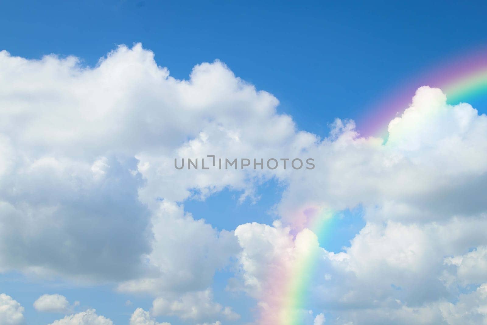 Cloudscape rainbow of natural sky with blue sky and white clouds and colorful rainbow in the sky use for wallpaper background