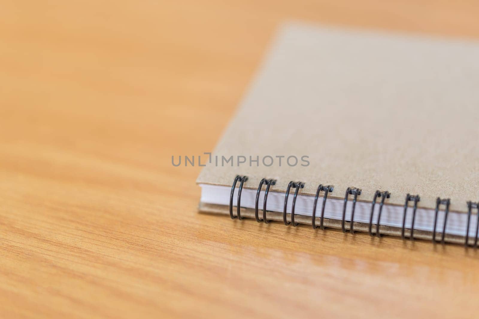 Notebook or note paper sheet in retro style with brown cover and blank white paper on wooden table or desk in business and education concept