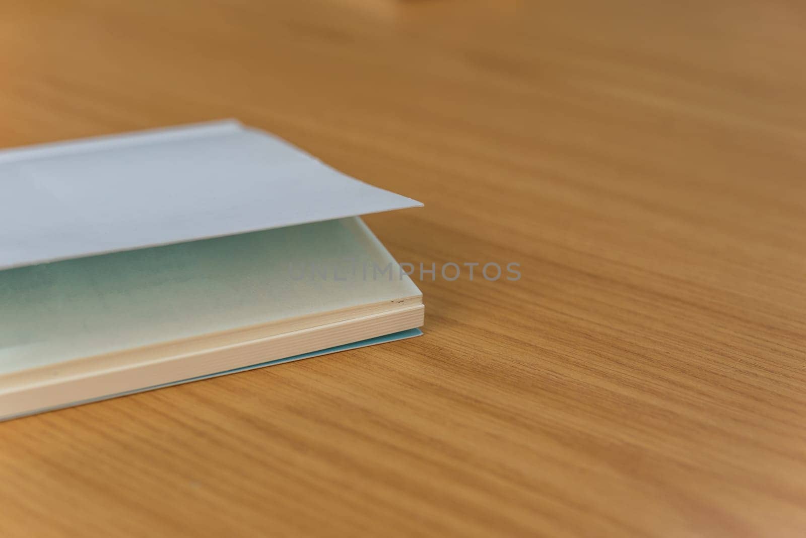 Notebook or note paper sheet in retro style with brown cover and blank white paper on wooden table or desk in business and education concept