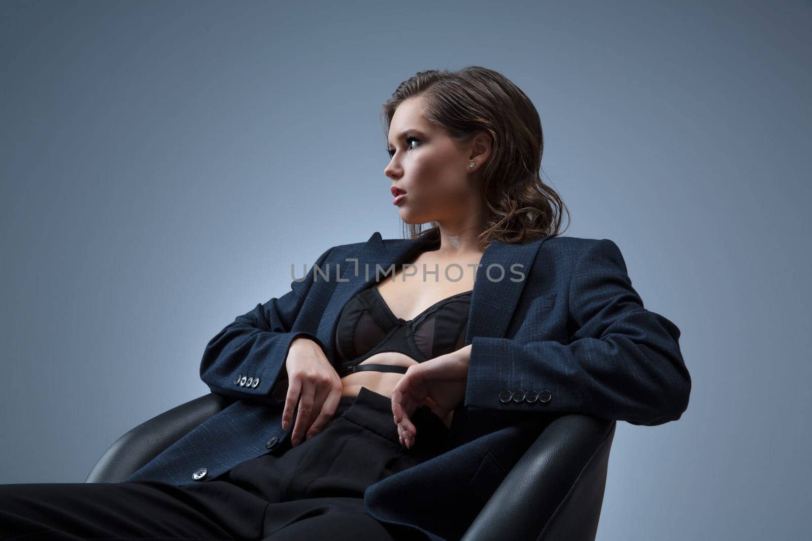 A stylish studio photoshoot featuring a model wearing a chic blazer over a trendy top, set against a neutral background. Perfect for highlighting modern fashion and elegant styling