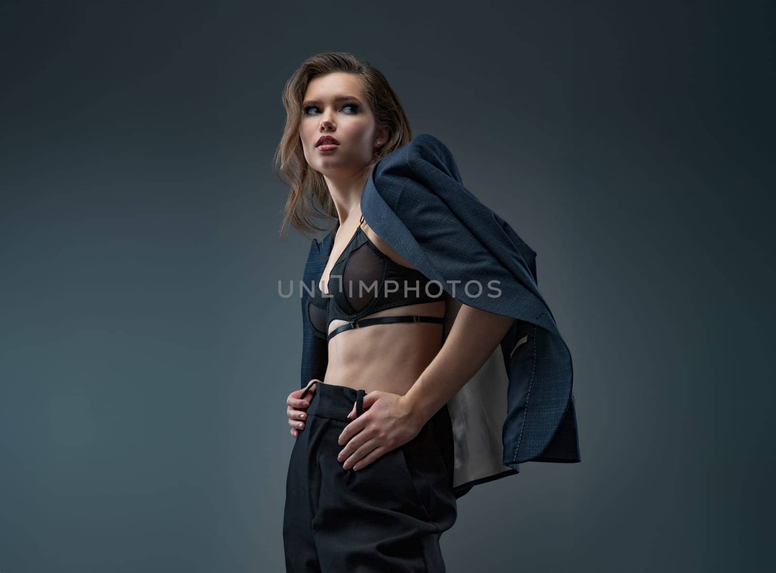 A stylish studio photoshoot featuring a model wearing a chic blazer over a trendy top, set against a neutral background. Perfect for highlighting modern fashion and elegant styling