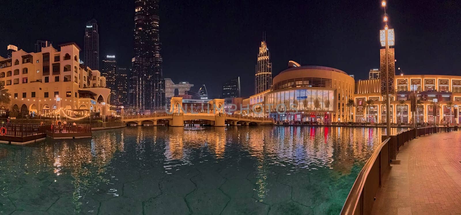 UAE, Dubai, 10 December 2024: The famous shopping center Dubai Mall and Burj Khalifa skyscraper at dusk, Dubai's sights and skyscrapers illuminated at night, palm trees. High quality photo