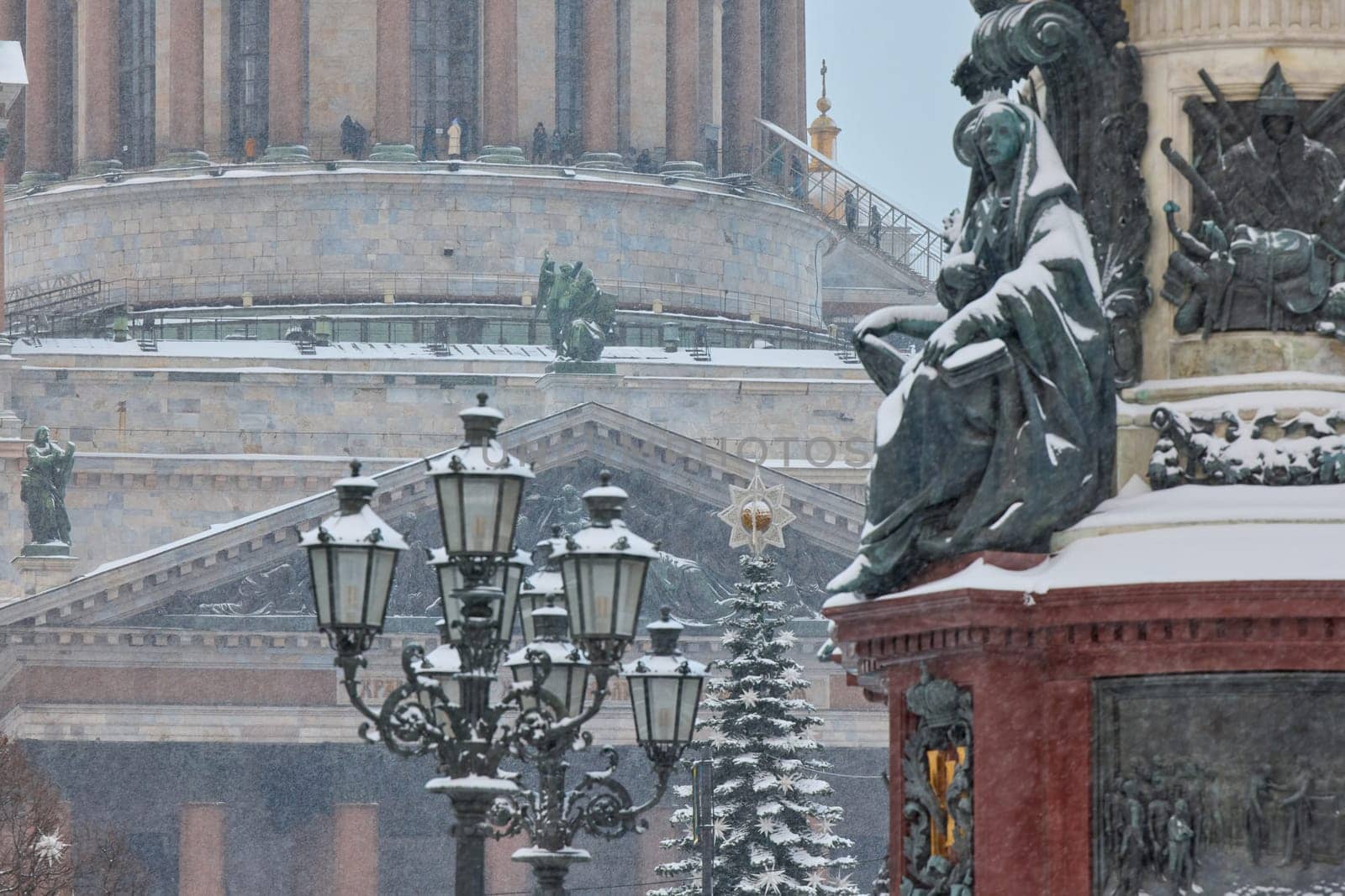 a snow-covered New Year's city decorated for the celebration of the new year, the golden dome of St. Isaac's Cathedral, walking tourists. High quality photo