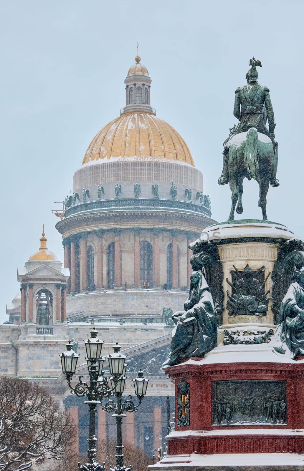 a snow-covered New Year's city decorated for the celebration of the new year, the golden dome of St. Isaac's Cathedral, walking tourists. High quality photo