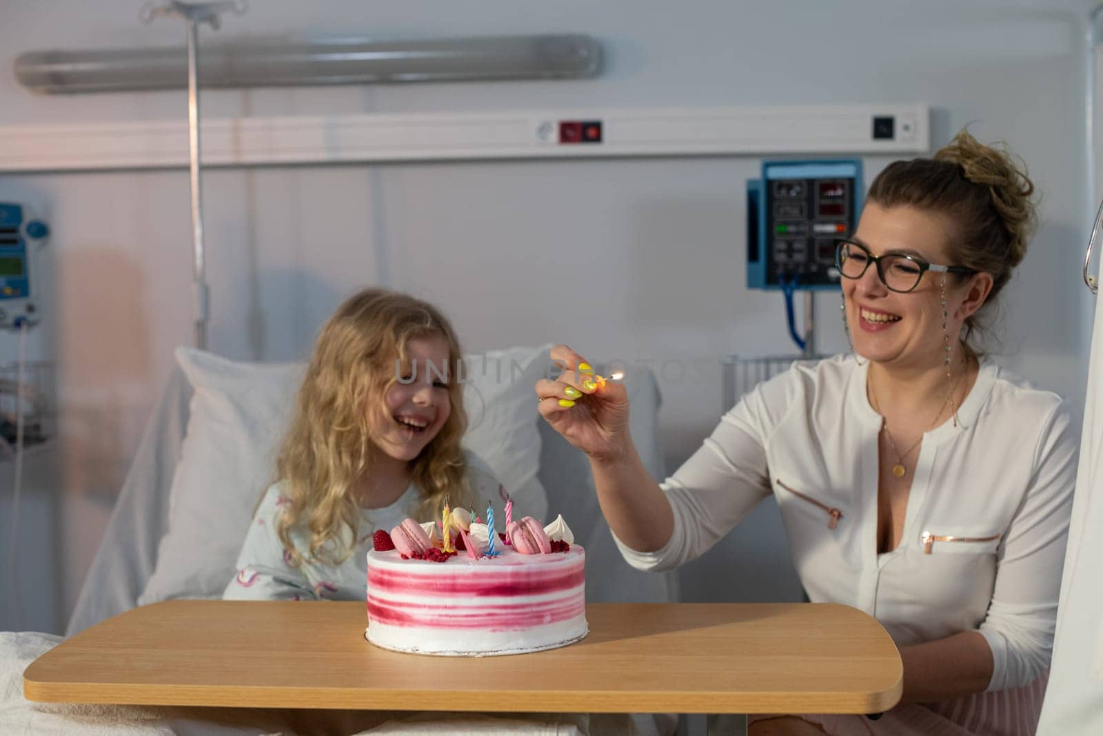 A heartwarming and truly joyful moment of celebration featuring a child and a delicious cake in a hospital setting