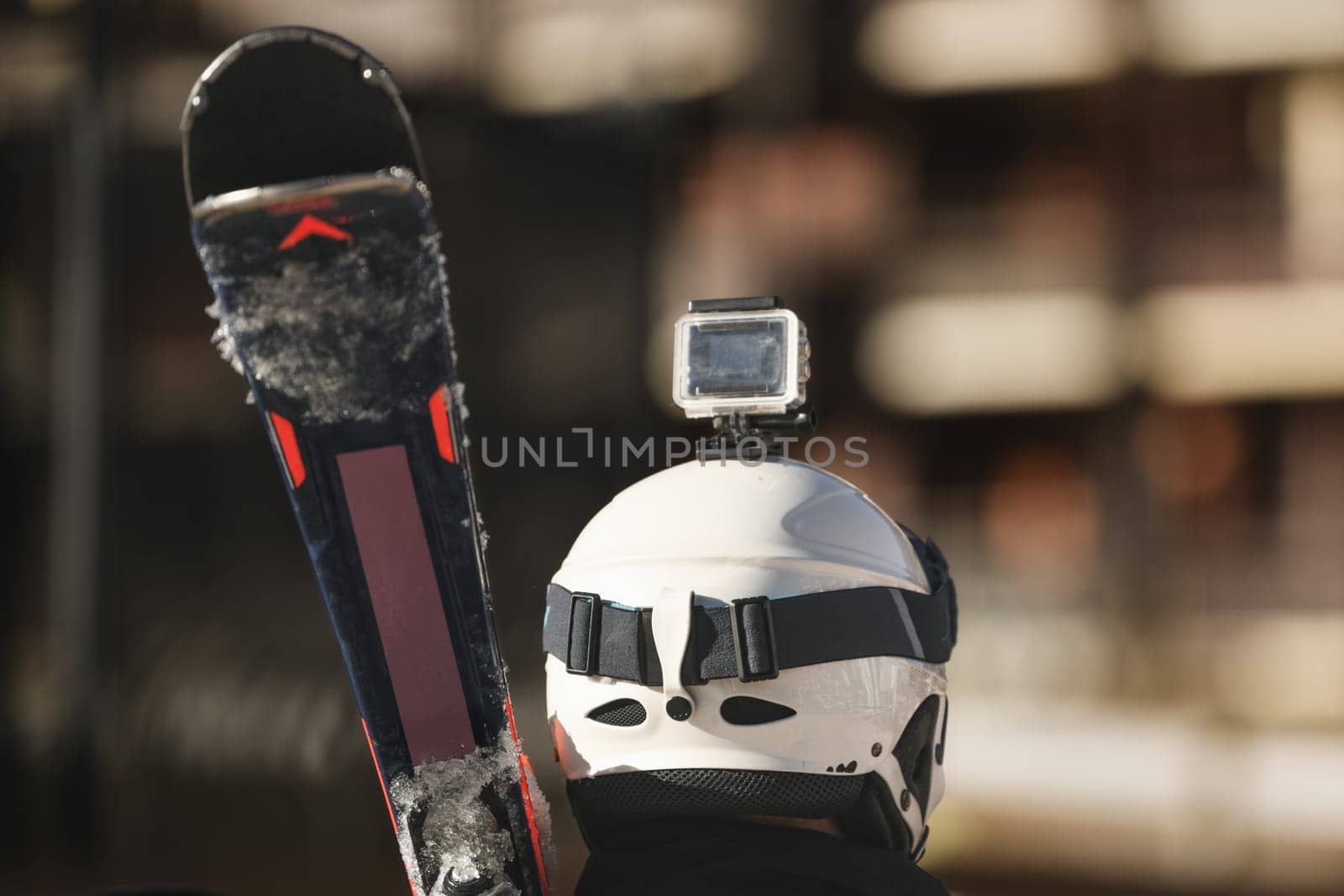 Blogger skier with skis, protective helmet and video camera on a helmet in the mountains