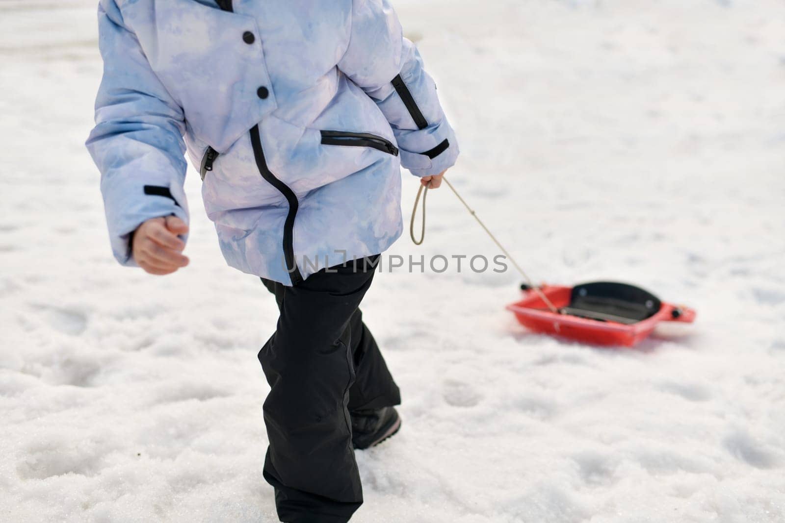 A boy with bob sledding in the snow
