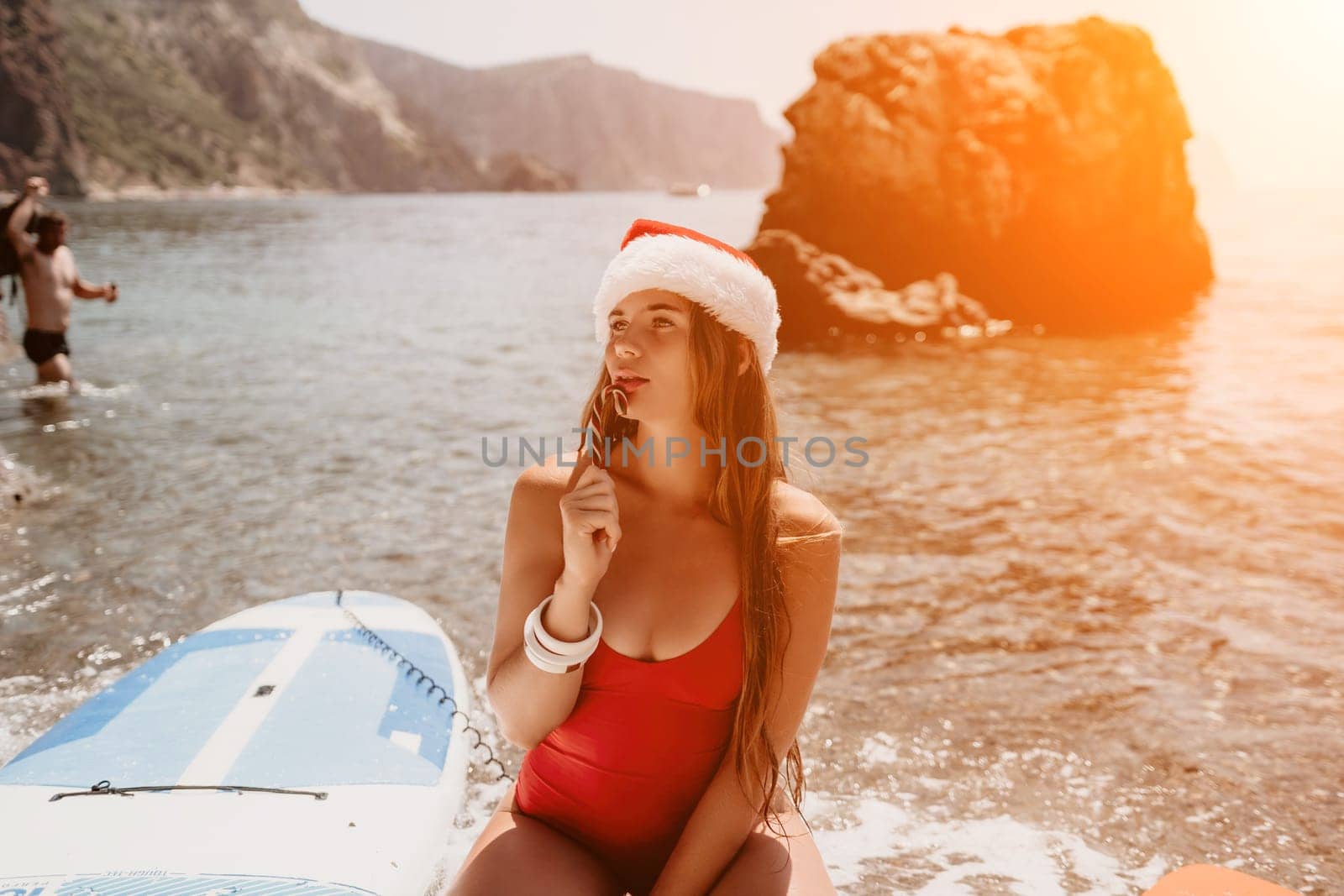 Woman travel sea. Happy tourist enjoy taking picture on the beach for memories. Woman traveler in Santa hat looks at camera on the sea bay, sharing travel adventure journey by panophotograph