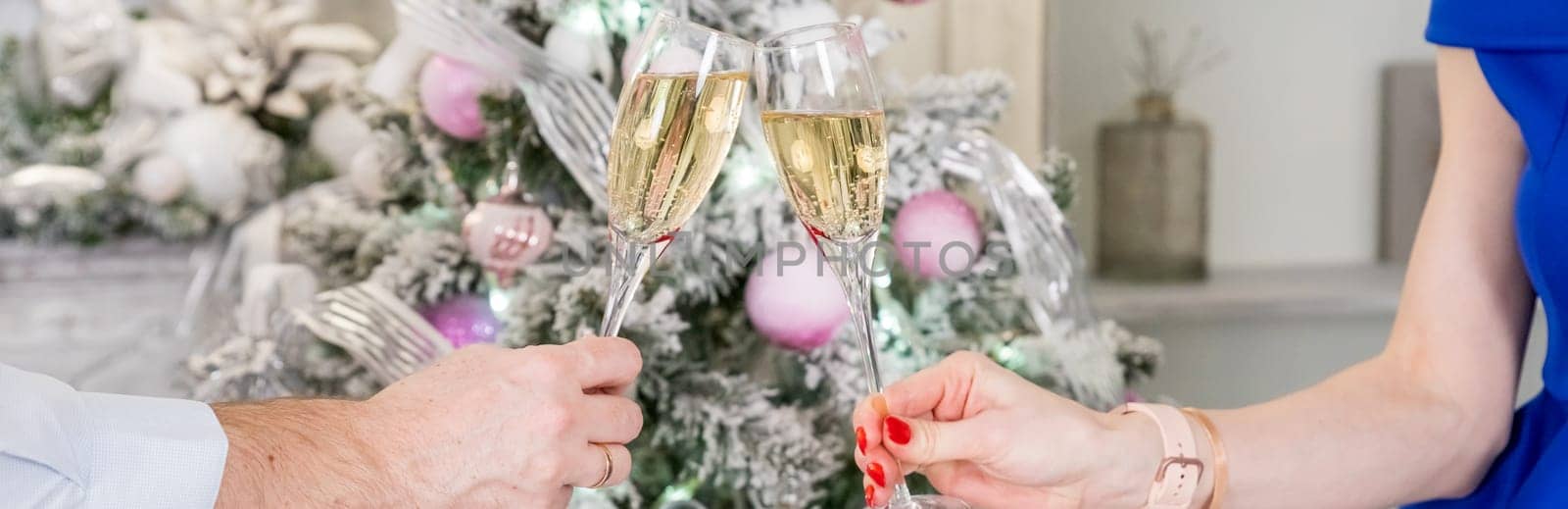 Two glasses with sparkling champagne wine in hands, concept for holiday,