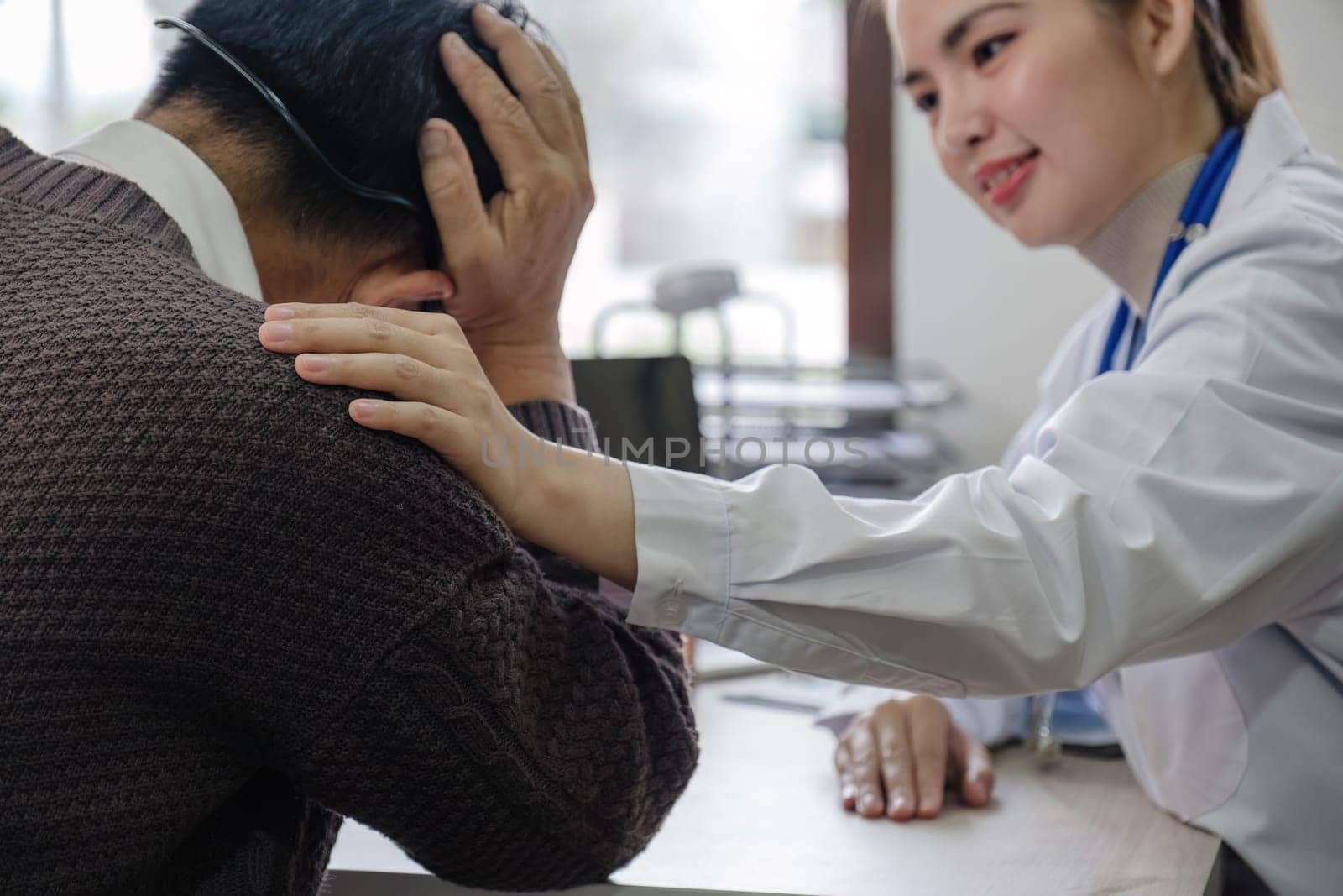 A female doctor is giving advice on diseases and medicine to an elderly male patient. 60s who has a headache Concept of health check and stress disease by wichayada