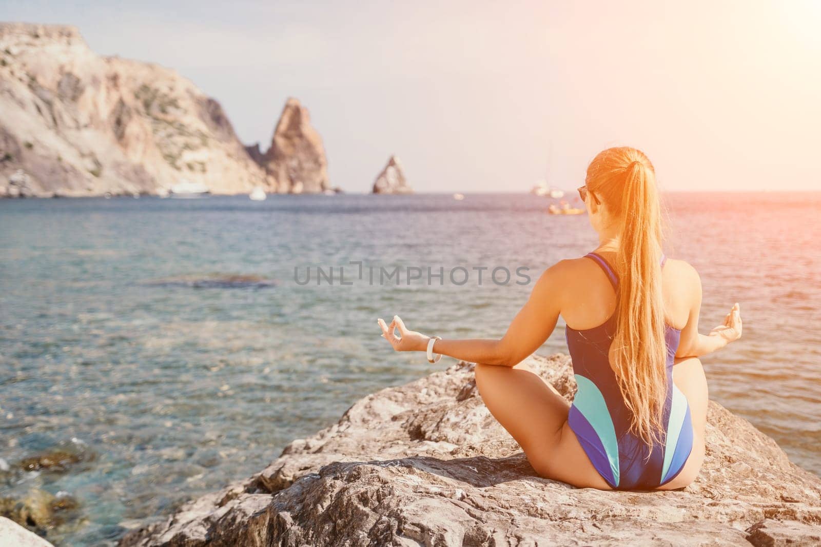 Woman sea yoga. Happy woman meditating in yoga pose on the beach, ocean and rock mountains. Motivation and inspirational fit and exercising. Healthy lifestyle outdoors in nature, fitness concept. by panophotograph