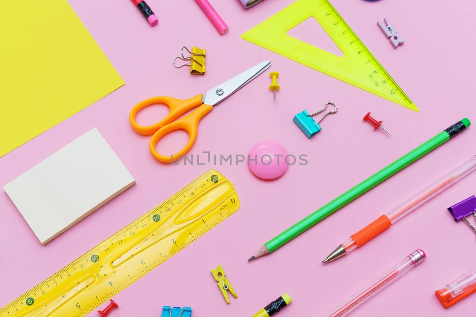 Supplies creative tools for school creative work on pink background with pattern stationery, colored paints brushes pencils, pens notepad on a spiral copy space, flat set, mock up