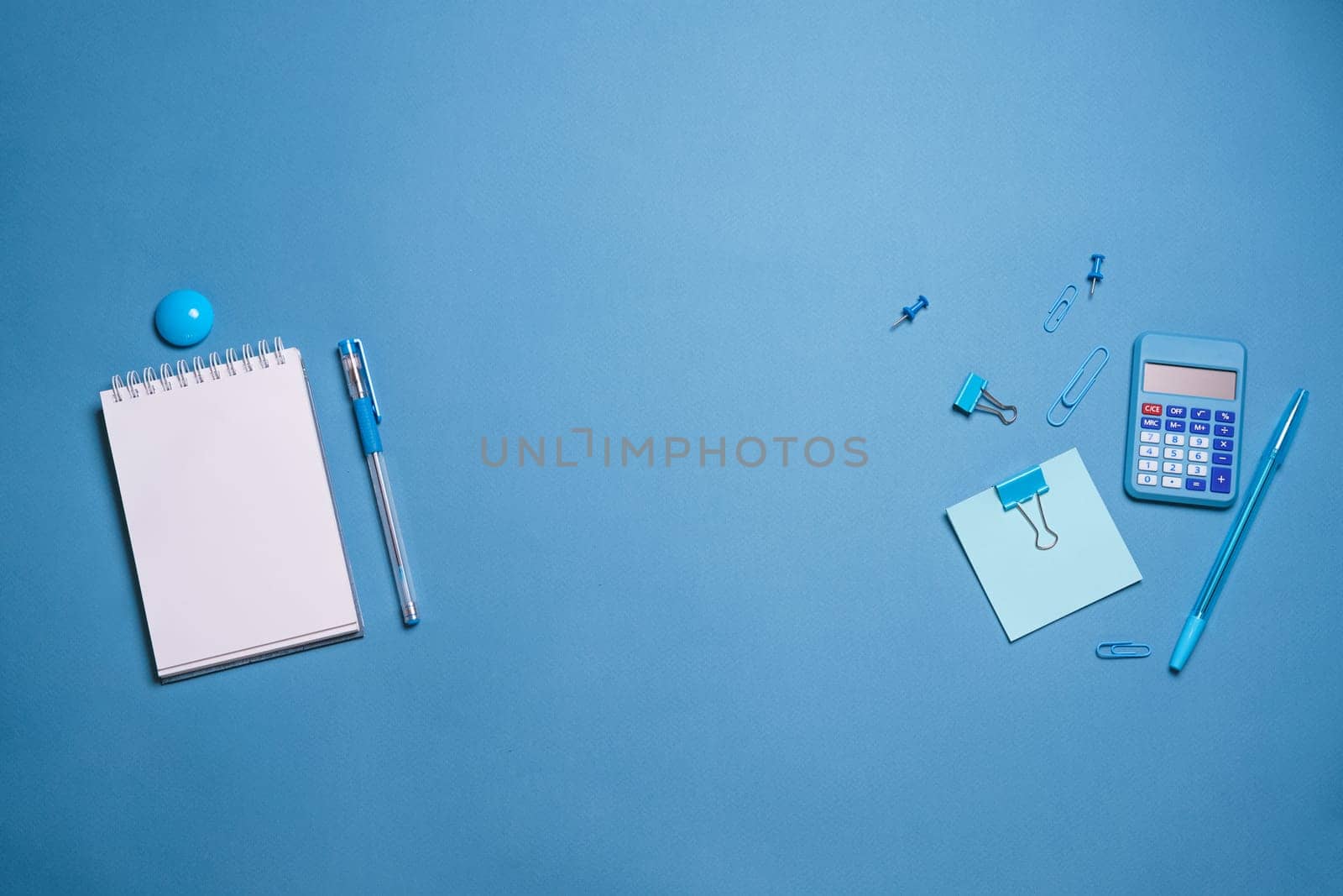 Stationery colorful supplies for writing pens pencils, on colored paper on a blue background. Back to school. Office supplies