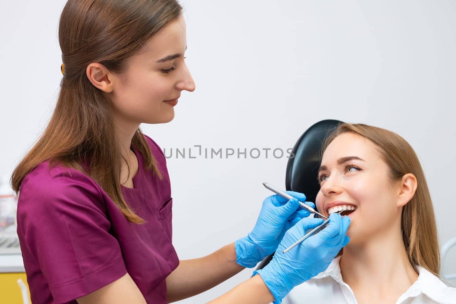 Dental treatment is being administered by the dentist to a female patient with a perfect smile. by vladimka