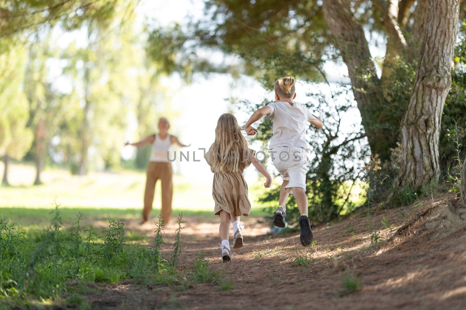 Kids playing and running through a sunny forest path