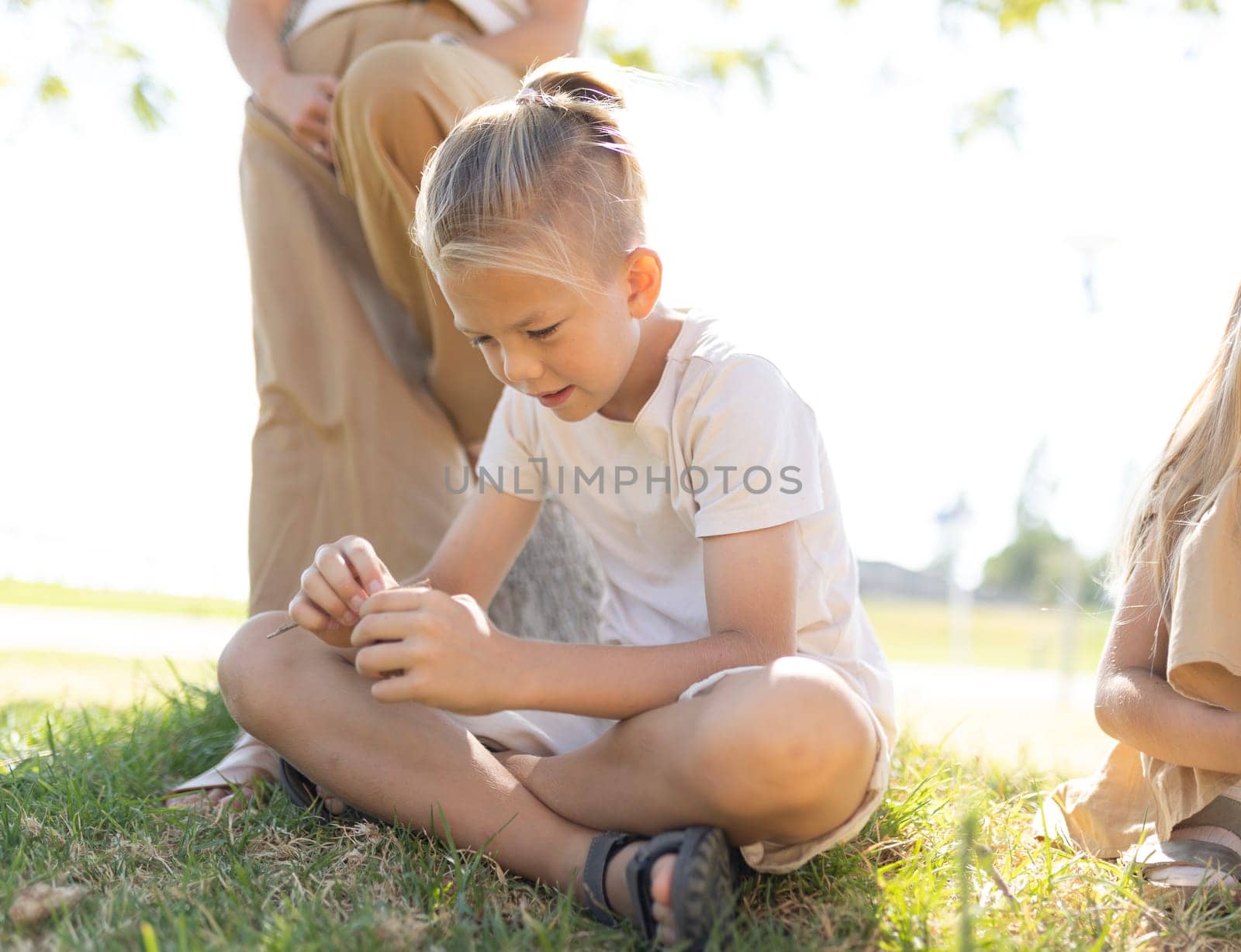 Child sitting cross-legged, focused on object in hands