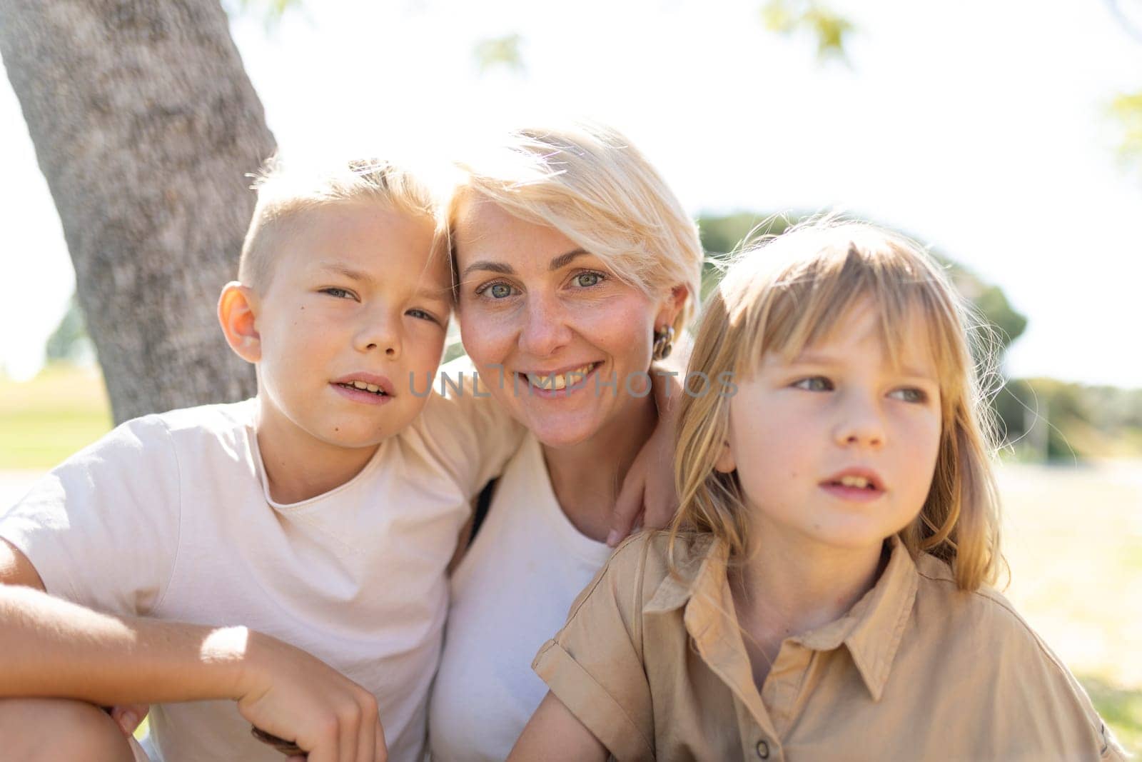 Smiling mother with two children enjoying a sunny day outside