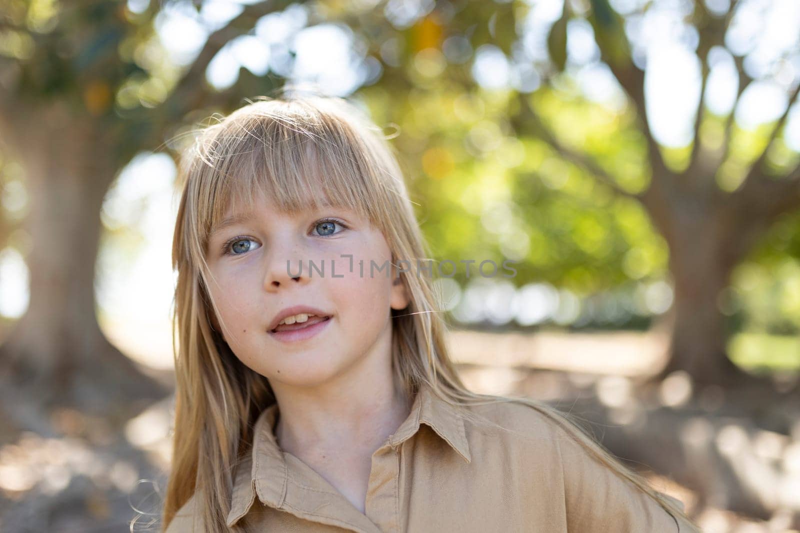 Smiling girl in nature with trees and sunlight