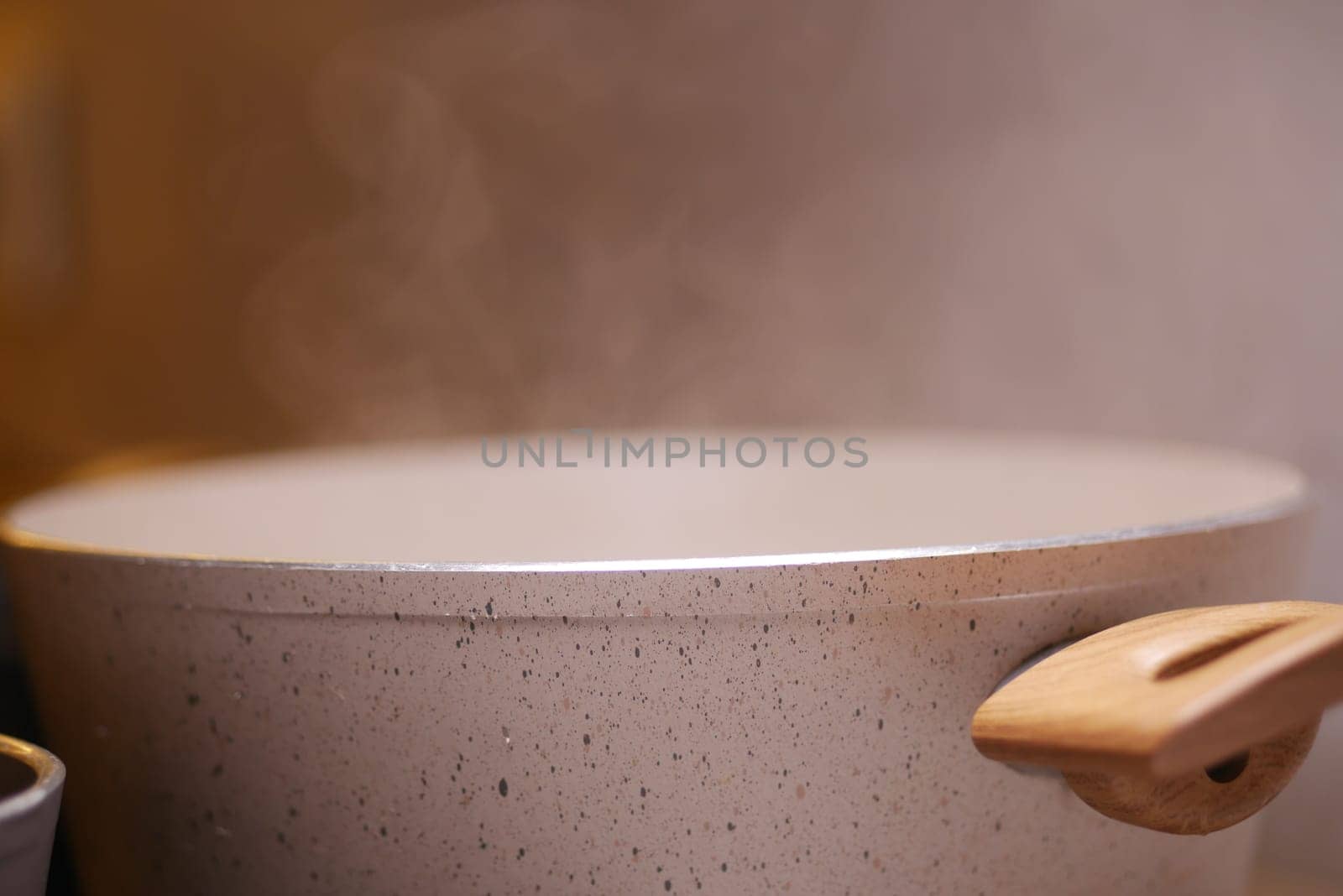 A large pot filled with steam is on the stove, indicating cooking.