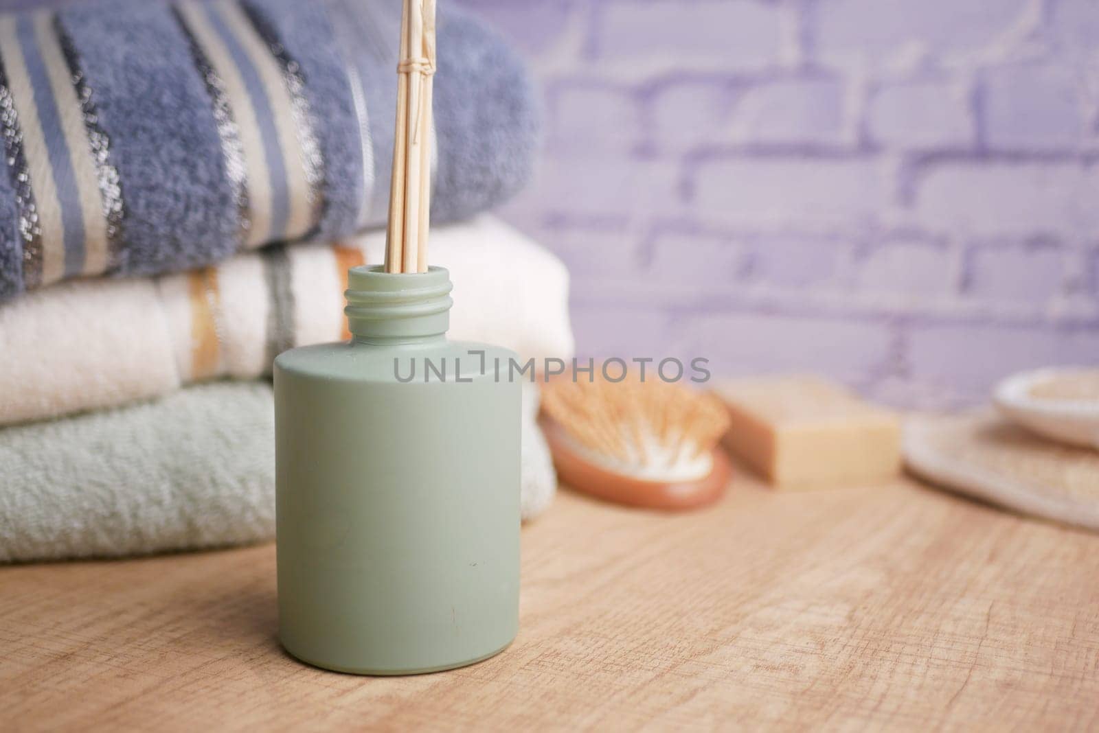 An inviting spa area features a diffuser, towels, and natural decor.