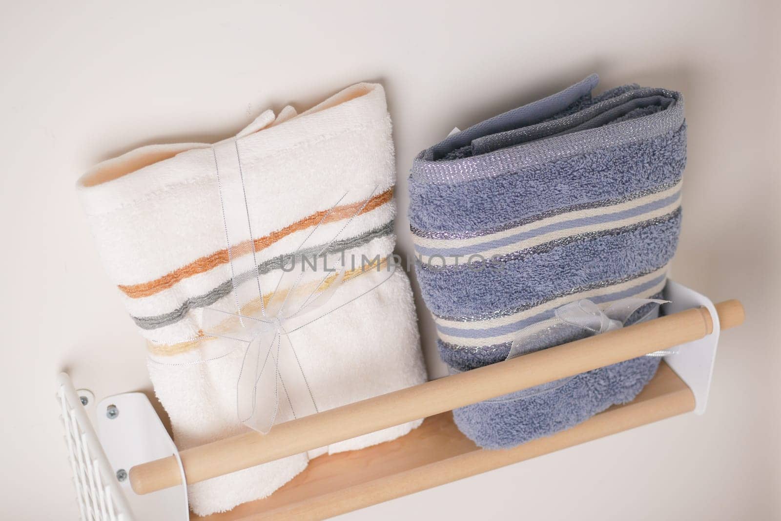Two folded towels sit on a wooden rack, adding softness to the bathroom decor.