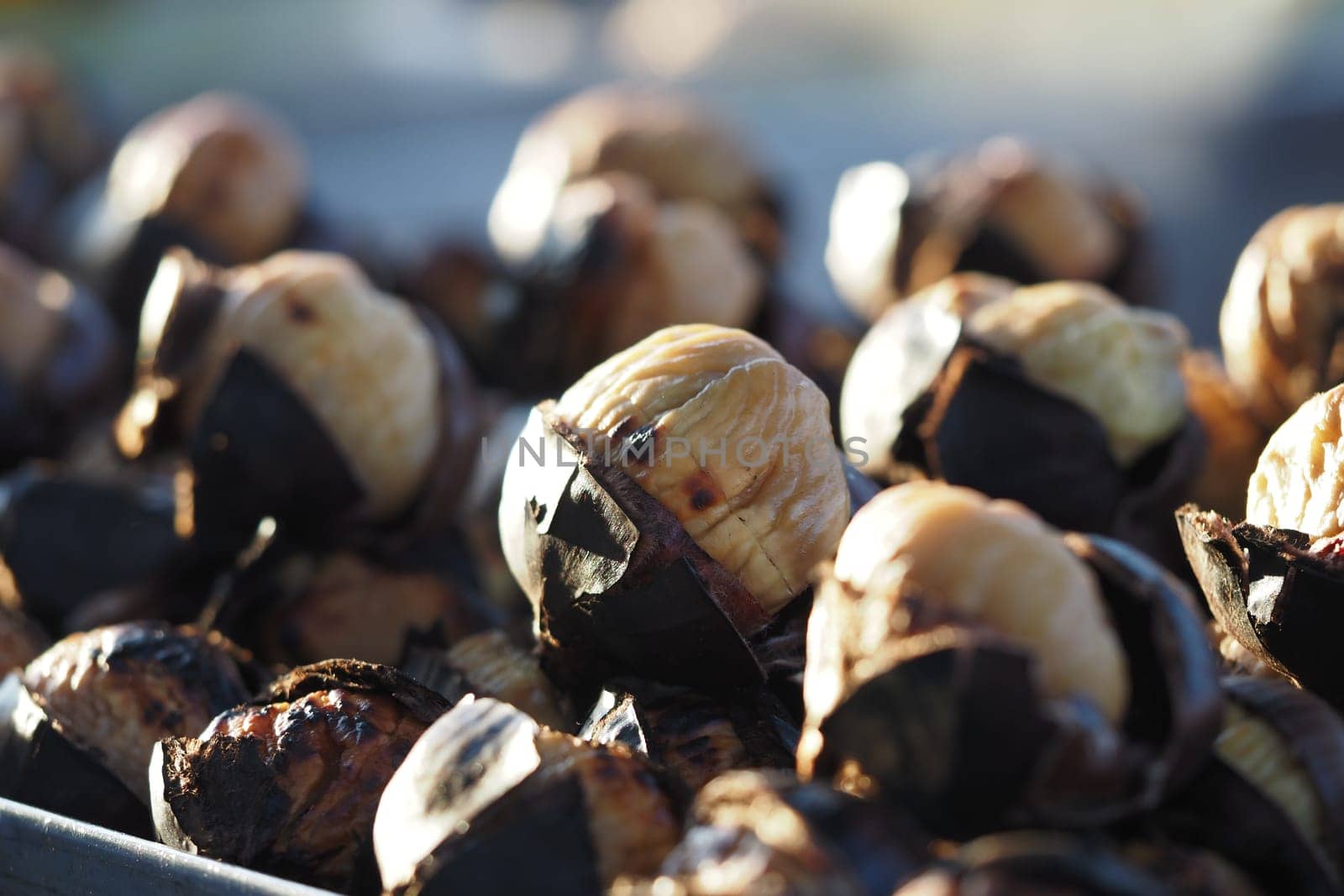 Roasted chestnuts displayed at a market, inviting customers to enjoy.