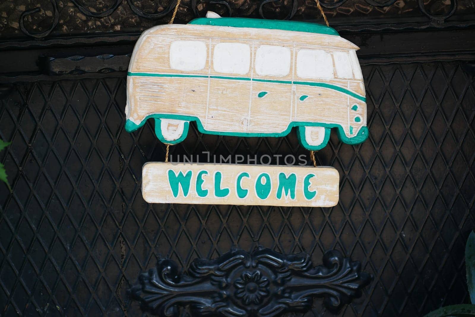 A colorful wooden sign features a vintage camper van design, welcoming visitors.
