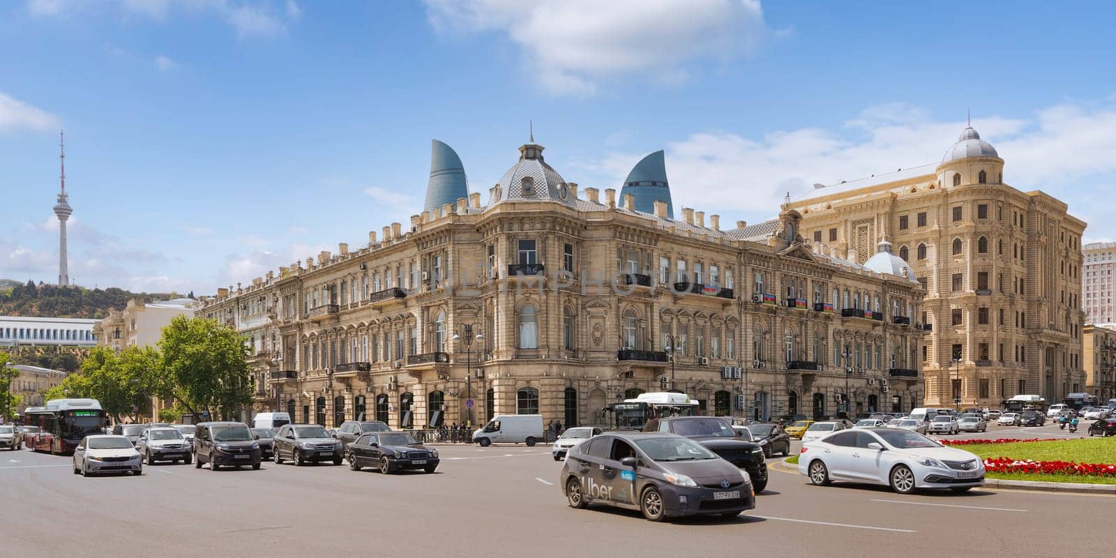 Baku, Azerbaijan - May 10, 2024: Historic Palace of Mirtaghi Babayev stands prominently, surrounded by traditional architecture. Flame Towers loom in the background. Baku TV Tower in the far end