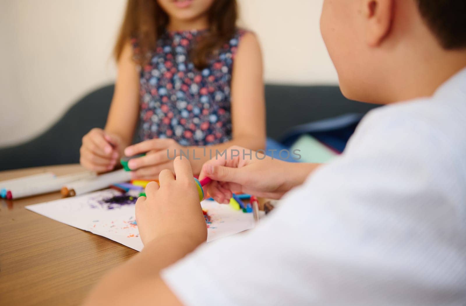 Children engaging in creative crafting activity with colorful materials on a table, fostering teamwork.