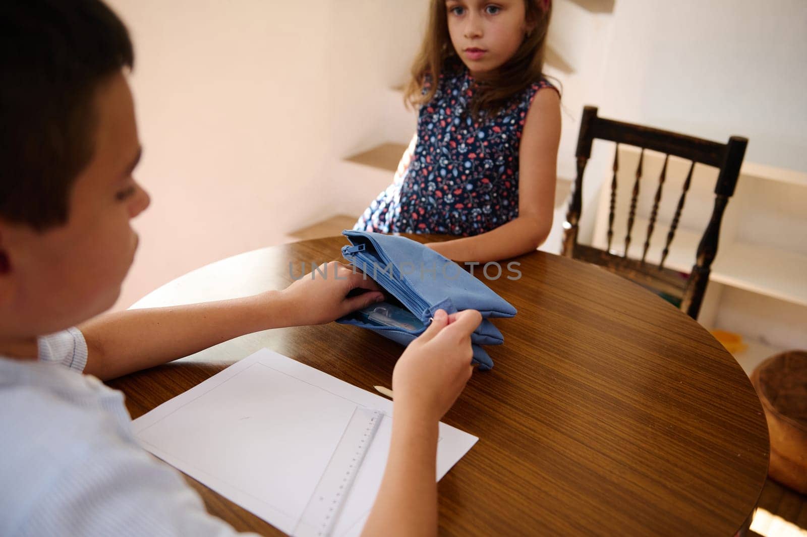Young children interact while seated at a table in a bright, peaceful home environment, evoking everyday life and calm moments.