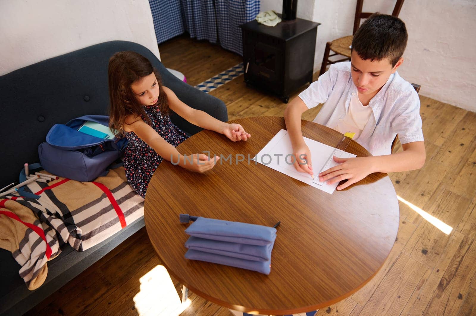 Two children working together at a table on homework tasks, fostering collaboration.