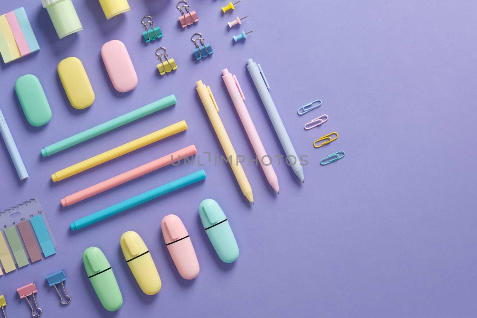 Stationery banner in green, yellow, pink and blue pastel colors on light purple background. Space for your text.