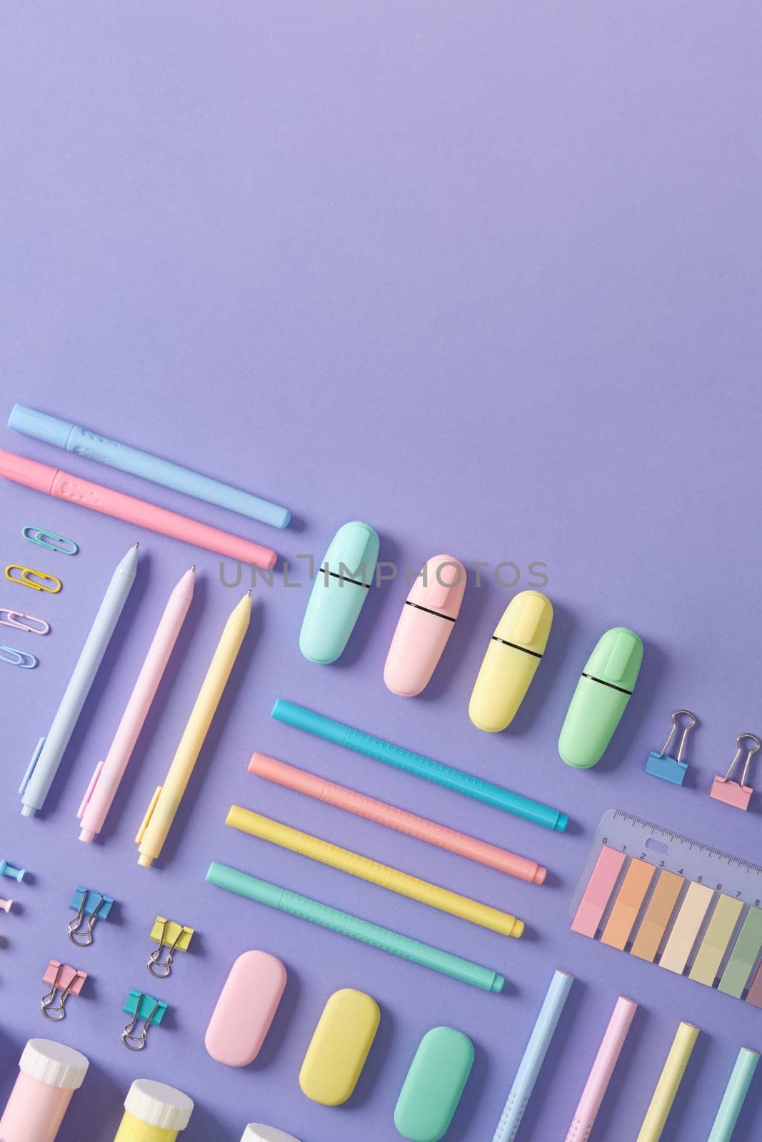 Stationery banner in green, yellow, pink and blue pastel colors on light purple background. Space for your text.