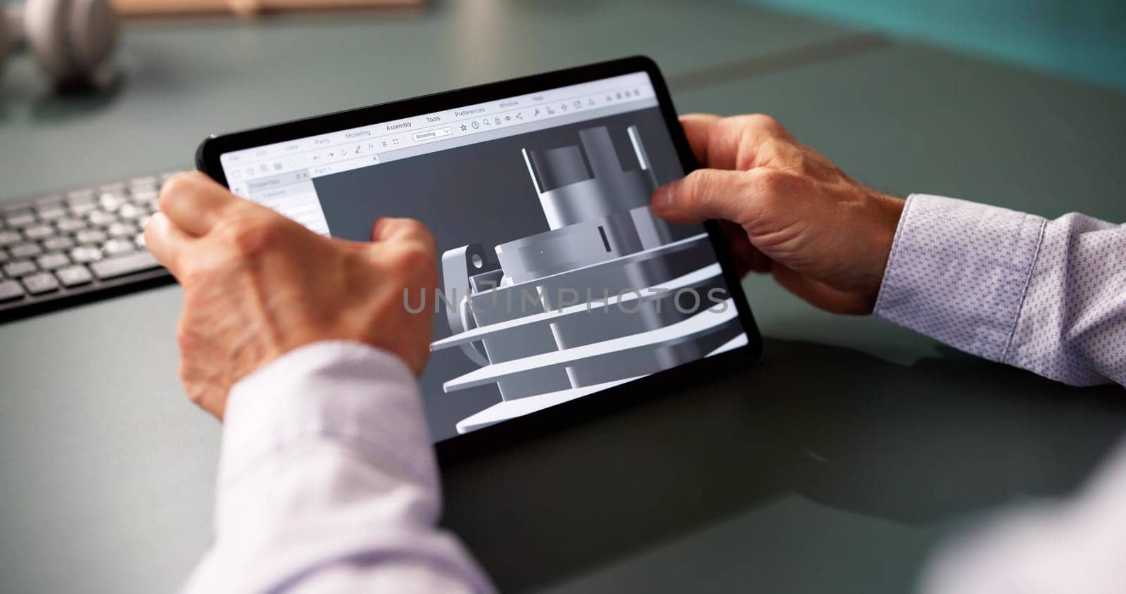 Male Engineer Developing Mechanical Parts Using 3D CAD Software On Laptop At Tablet Office