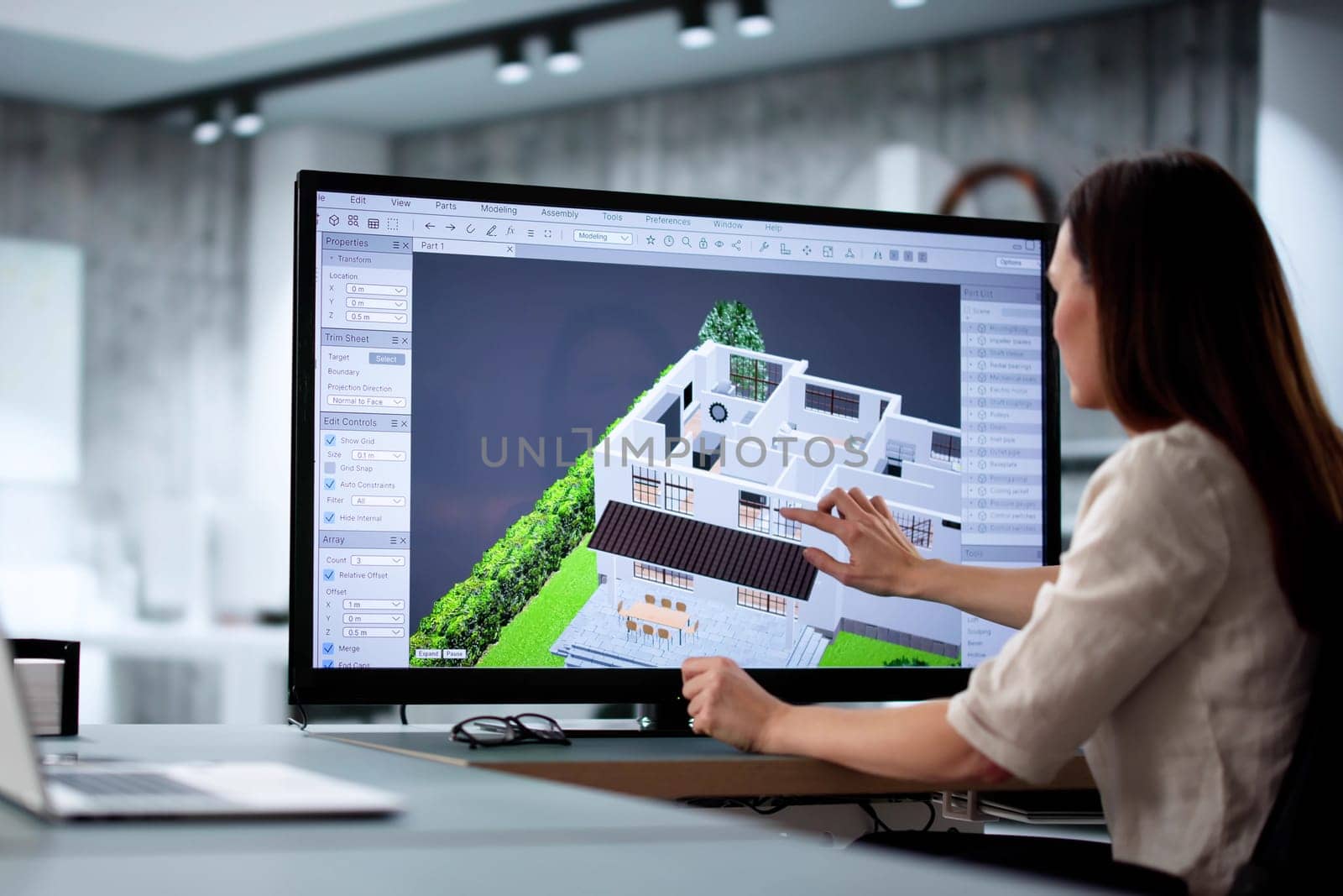 Female architect using 3D software to remodel estate floor plan.