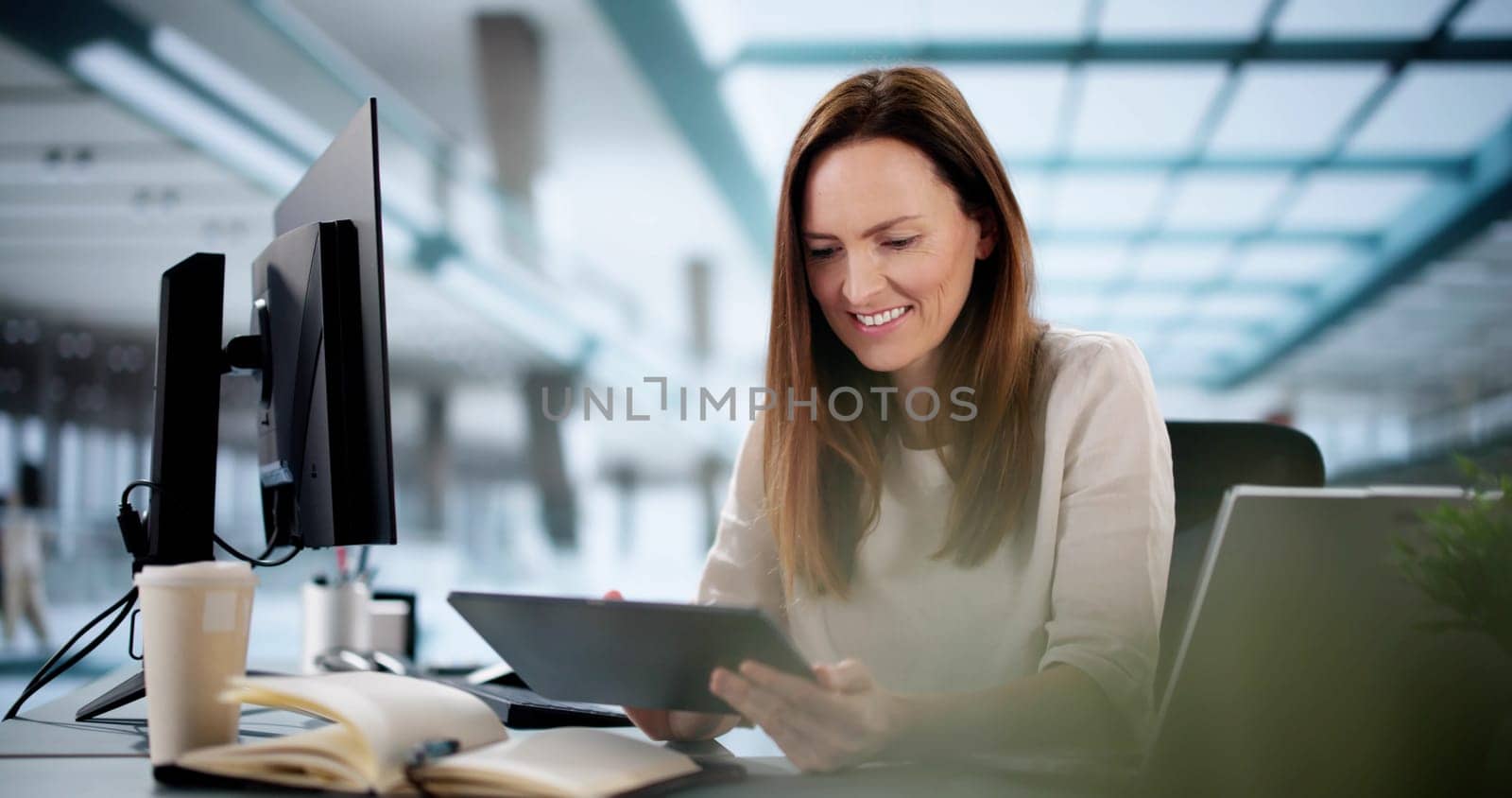 Indian woman in suit using tablet for financial analysis online.