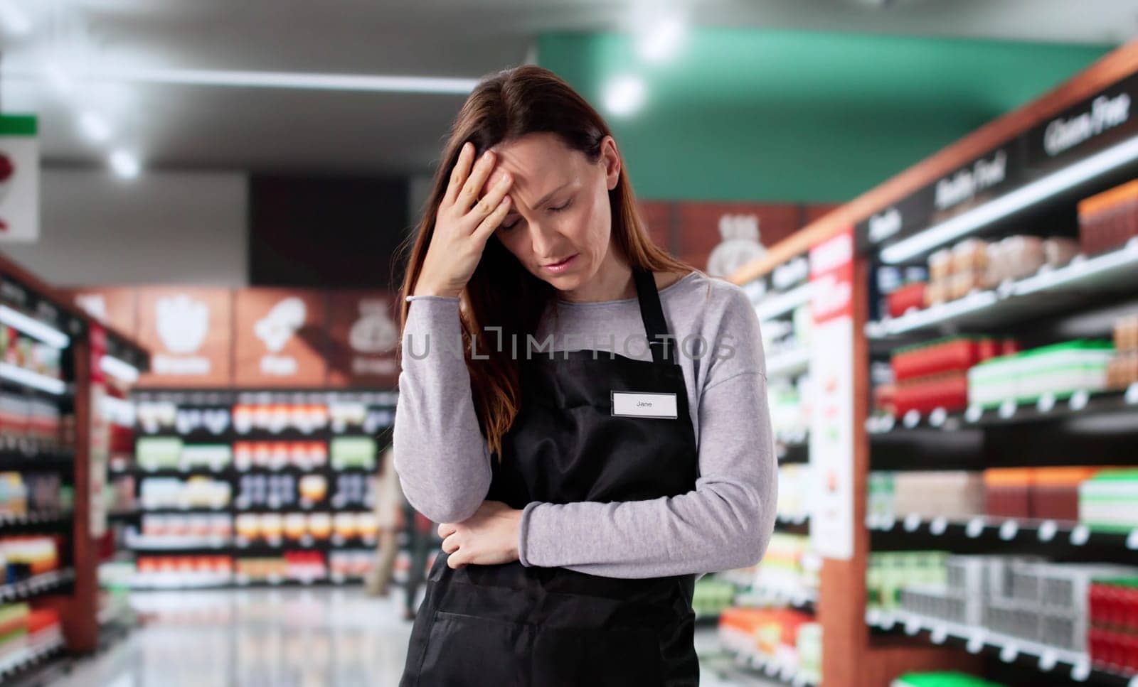 Stressed Retail Store Clerk Reading Report, Feeling Unhappy and Lazy.