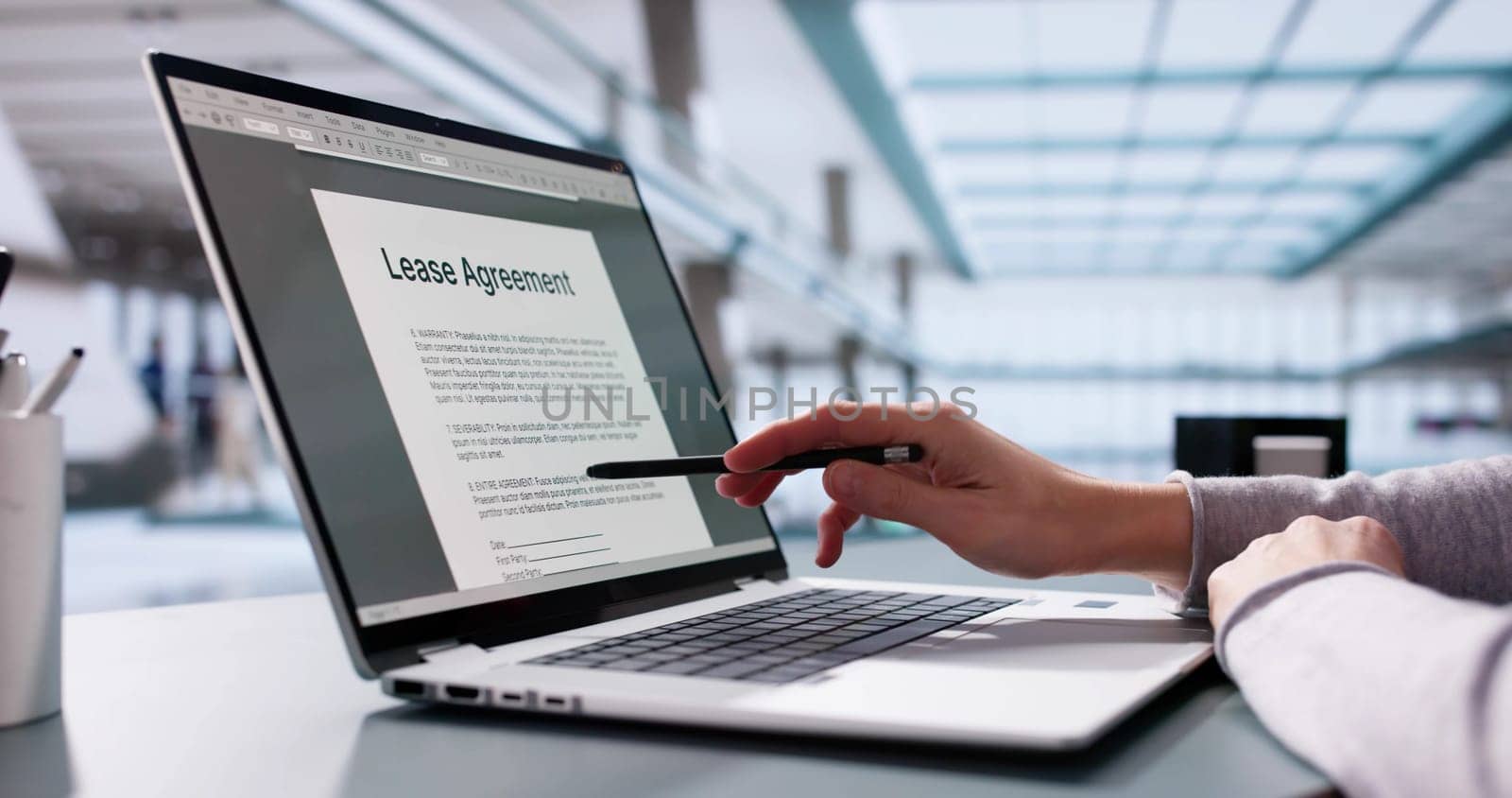 Female businesswoman reviewing leasing contract on laptop, considering property investment.