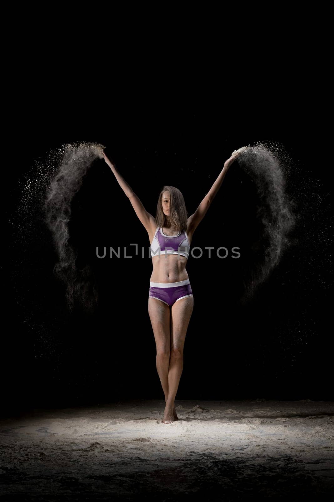 Slim girl in lingerie in white dust cloud full-length view